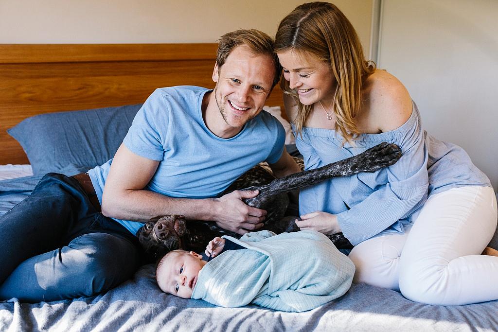 New family on the bed with their dog