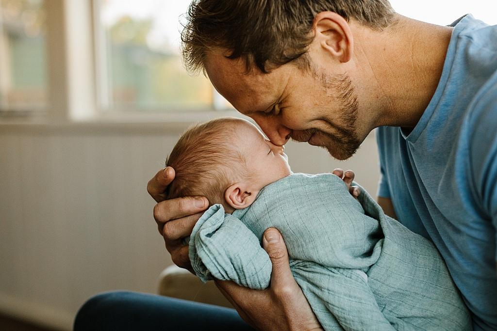 New dad touches noses with his newborn son