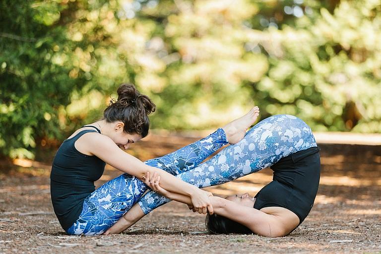 Two people in a combined yoga pose