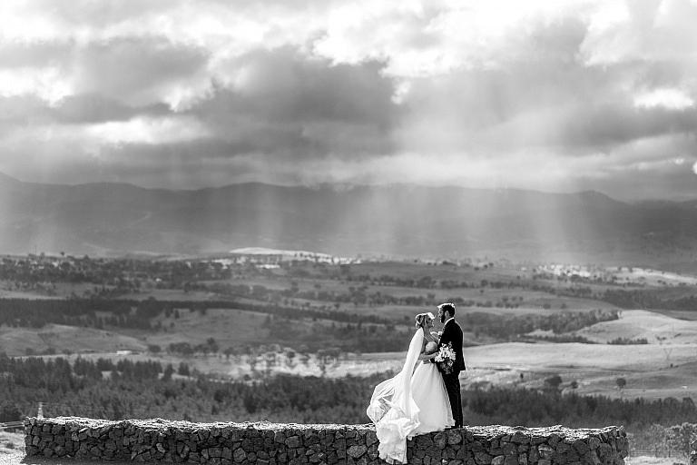 Bride and Groom stand before the rain clouds