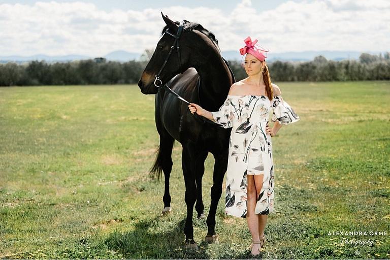 Woman holds horse in fashion dress