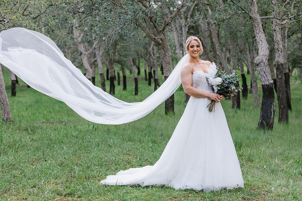 Bride posing with veil billowing
