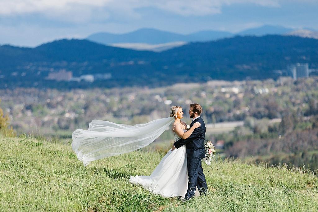 Bride and groom share intimate moment with mountains in the background