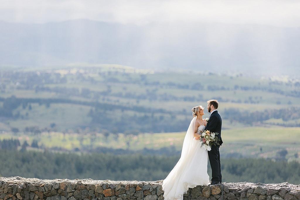 Bride and groom with clouds behind them