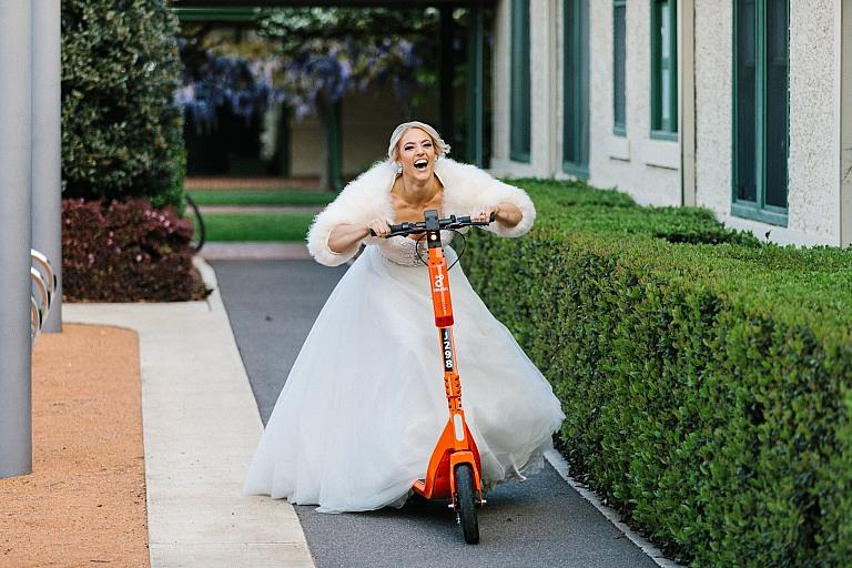 Bride rides scooter in wedding dress