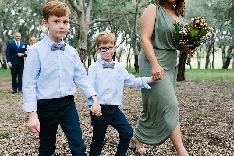 Ring bearers walk with bridesmaid down the aisle