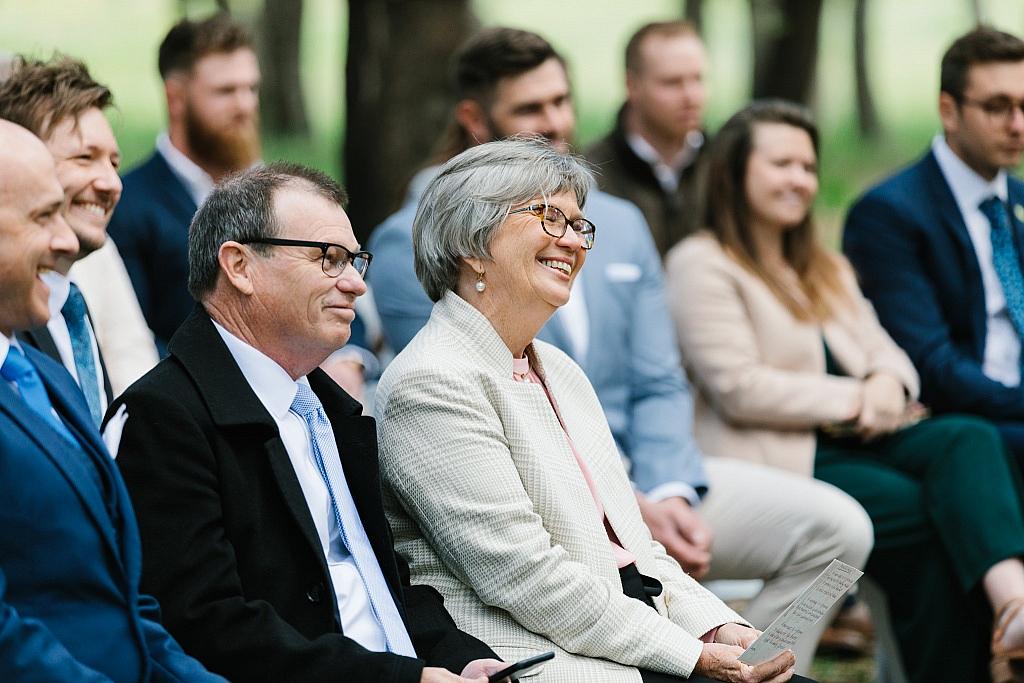 Mother of the groom smiles at couple