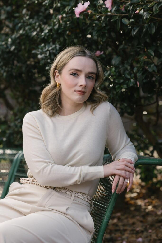 Women sits on a bench for her headshot in Canberra